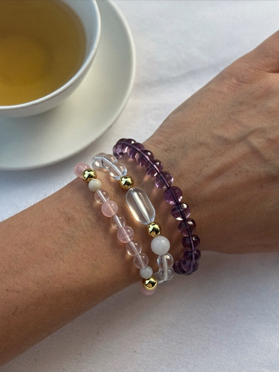 Three crystal bracelets stacked on a wrist